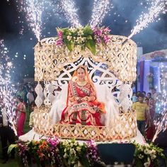 a woman sitting on top of a cake surrounded by fireworks