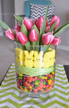 a glass vase filled with candy and peep - ear candies on top of a table