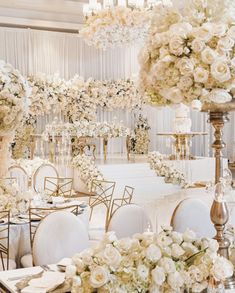 an elegant wedding setup with white flowers and gold chairs