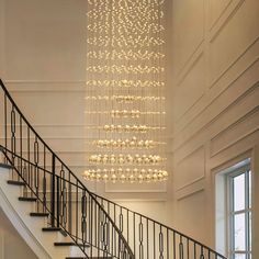 a chandelier hanging from the side of a stair case