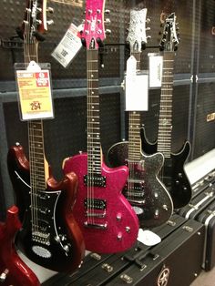 guitars are lined up on display in a store