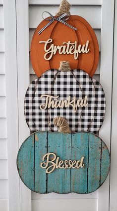 three pumpkins are stacked on top of each other with the words grateful and happy