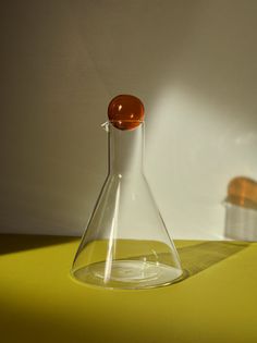 a glass flask sitting on top of a yellow table