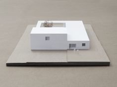 a white house sitting on top of a cement floor