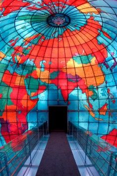 the inside of a building with a colorful world map on it's glass walls