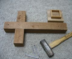 a hammer and wooden block laying on the floor next to some screwdriver nails