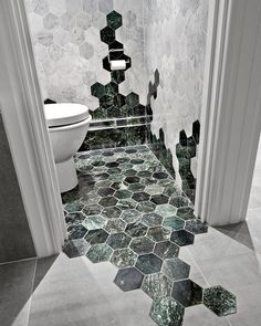 a bathroom with hexagonal tiles on the floor and walls in black and white