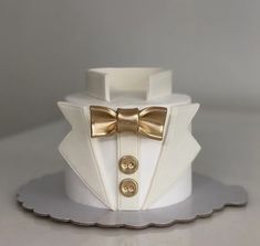 a white cake with a gold bow tie on it