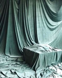 an image of a cloth covered table in the middle of a room with drapes on it