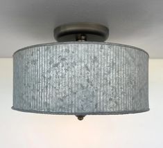 a close up of a light fixture with a fabric shade hanging from the ceiling above it