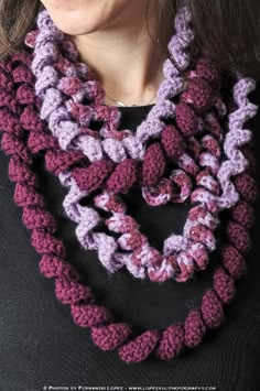 a woman wearing a purple and pink crocheted scarf