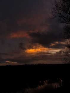 the sky is dark and cloudy at night, with some clouds in the foreground