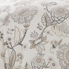 an image of a bed with floral print on the sheets and pillowcases that are not made