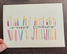 someone holding up a birthday card with candles on it