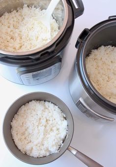 rice is being cooked in an instant pot with a ladle next to it on a white surface