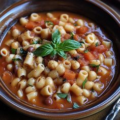 a bowl filled with pasta and vegetables on top of a table