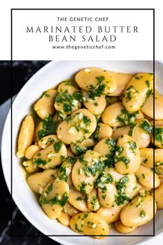 a white bowl filled with pasta covered in cheese and parsley on top of a black table