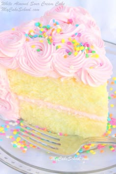 a piece of cake with pink frosting and sprinkles on a plate