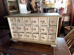 an old dresser with many drawers and knobs on it's sides in a shop