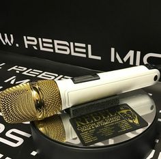 a microphone sitting on top of a table next to a black and white sign that says new reebl mic