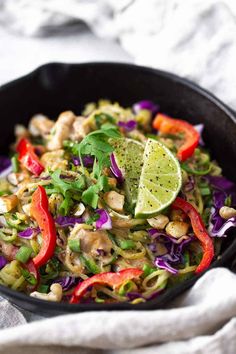 a skillet filled with stir fry vegetables and lime wedged avocado on top