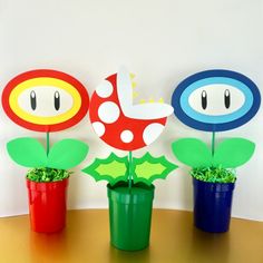 three potted plants with paper decorations in them