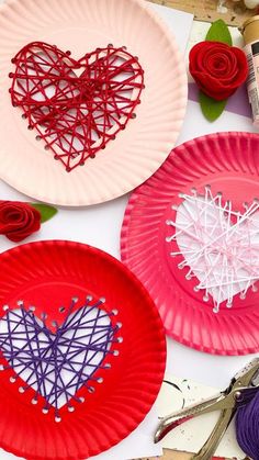 three paper plates with hearts on them next to scissors and thread spools in the shape of roses