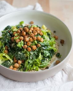 a white bowl filled with lettuce and chickpeas