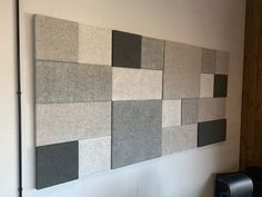 the wall is made up of squares and rectangles in grey, black, and white