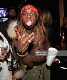 a man with dreadlocks making a silly face while holding a coffee cup in his hand