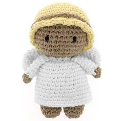 a small crocheted doll with a yellow hat and white coat on it's head