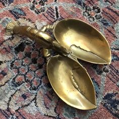 two brass spoons sitting on top of a rug