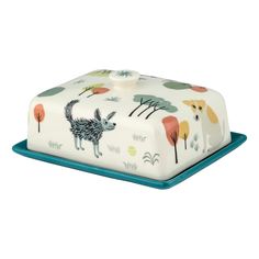 a white and blue cake with an animal design on the front, sitting on top of a