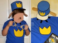 a child wearing a blue shirt and hat holding a pair of scissors in front of his face