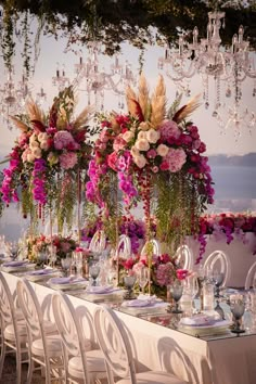 a table set up with flowers and chandeliers