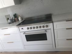 a white stove top oven sitting inside of a kitchen next to cabinets and counter tops