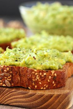 two pieces of bread topped with guacamole and sesame seeds