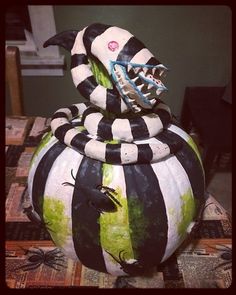 a black and white striped pumpkin sitting on top of a table