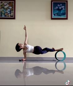 a woman is doing an exercise on a yoga mat in the middle of a room