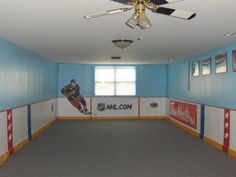 an empty room with blue walls and ceiling fans