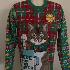 a green and red christmas sweater with a cat on it's chest that says help for the cheer