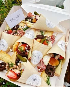 a box filled with lots of different types of food on top of paper wrappers