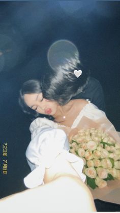 a woman holding a bouquet of flowers in her hands