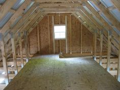 an attic with wooden framing and windows