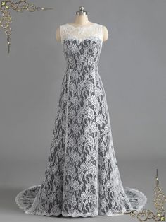 a white and black lace wedding dress on display with gold chains hanging from the back