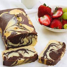 a chocolate swirl cake next to a bowl of strawberries