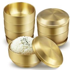 three gold containers with white rice in them