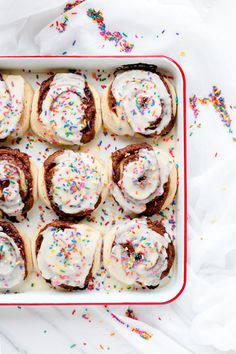 there are many donuts with white frosting and sprinkles