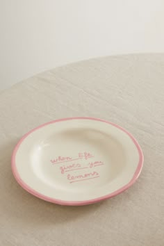 a pink and white plate with writing on it