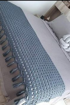 a bed that has some blankets on top of it and pillows in front of it